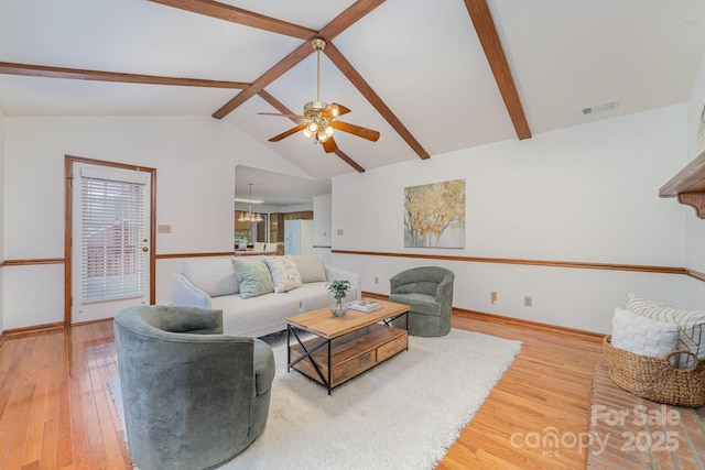 living area featuring lofted ceiling with beams, a ceiling fan, visible vents, and wood finished floors