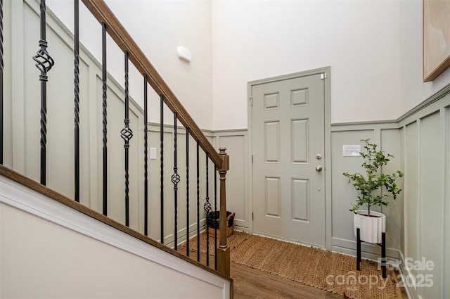 entrance foyer with a wainscoted wall, a decorative wall, and stairs