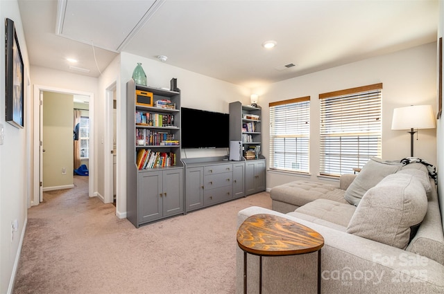 living area featuring recessed lighting, light colored carpet, visible vents, attic access, and baseboards