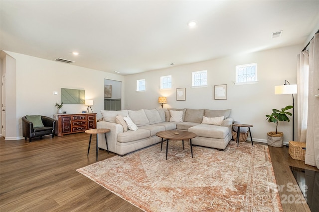 living area featuring wood finished floors, visible vents, and baseboards