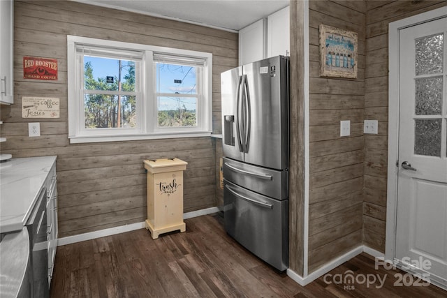 kitchen featuring dark wood-style floors, wooden walls, white cabinetry, and stainless steel refrigerator with ice dispenser