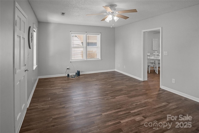 unfurnished bedroom with a textured ceiling, dark wood finished floors, a ceiling fan, and baseboards