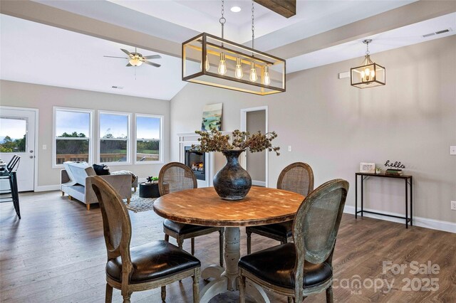 dining room featuring baseboards, visible vents, dark wood finished floors, vaulted ceiling with beams, and ceiling fan with notable chandelier