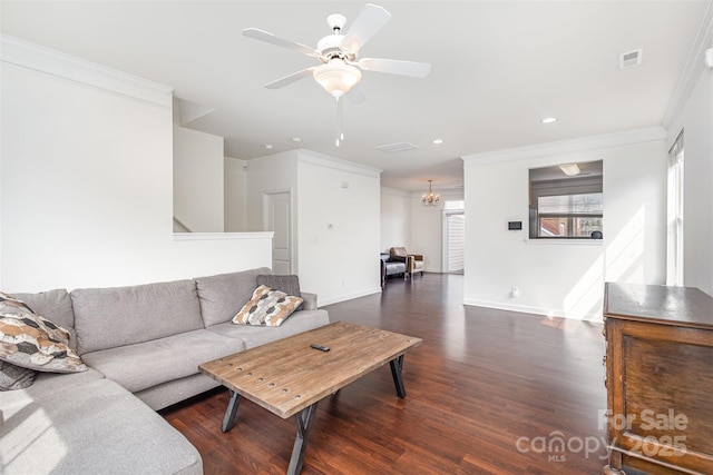 living area with dark wood finished floors, ceiling fan with notable chandelier, visible vents, and ornamental molding