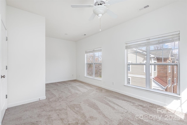 empty room featuring visible vents, baseboards, a ceiling fan, and carpet flooring