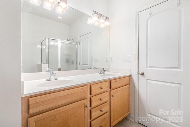 bathroom featuring double vanity, a shower stall, and a sink