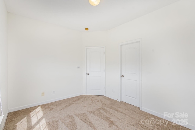 carpeted spare room featuring baseboards