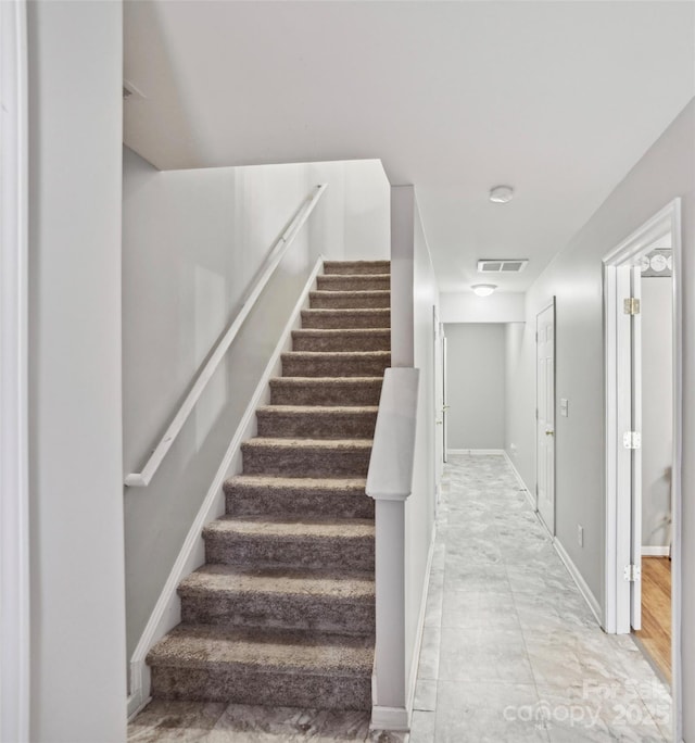 staircase with visible vents and baseboards