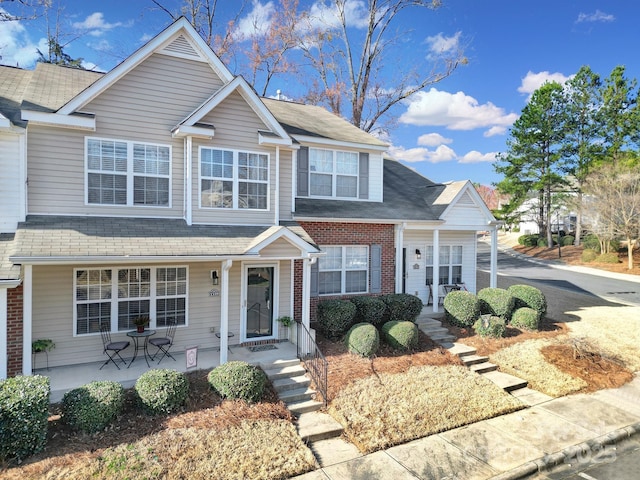 view of front facade with brick siding and covered porch