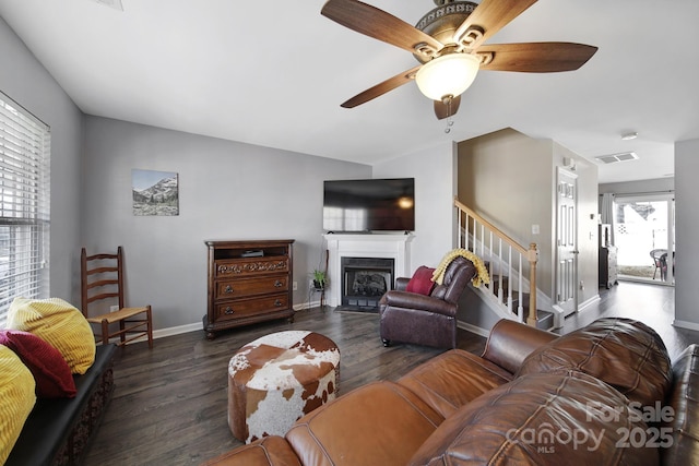 living area featuring visible vents, stairs, a ceiling fan, and wood finished floors