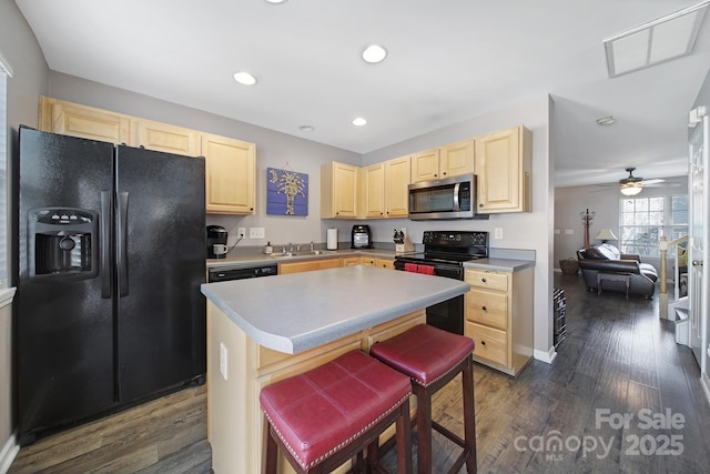 kitchen with recessed lighting, dark wood-style flooring, light brown cabinetry, black appliances, and a center island