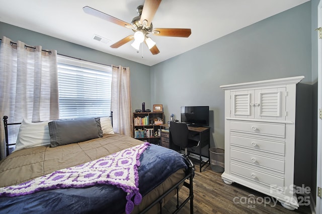 bedroom featuring dark wood finished floors, visible vents, and a ceiling fan