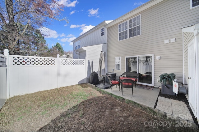 rear view of property featuring a patio and a fenced backyard