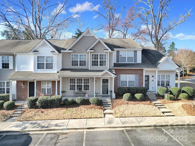 view of front of home with brick siding and covered porch