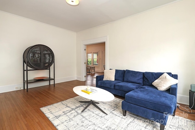 living area featuring crown molding, baseboards, and wood finished floors