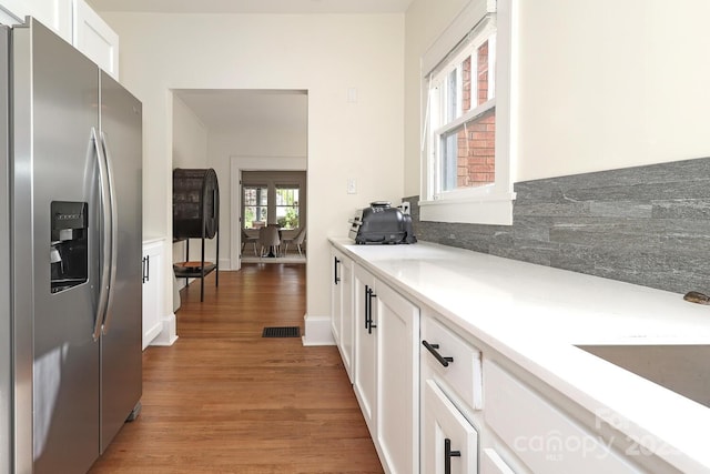 kitchen featuring visible vents, stainless steel fridge, light countertops, white cabinets, and light wood finished floors