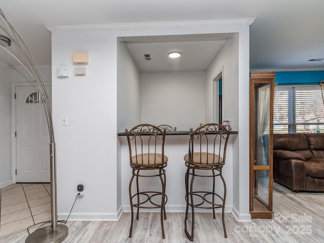 dining space with wood finished floors, visible vents, and baseboards