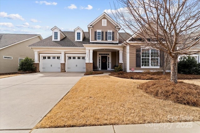 view of front of house featuring a front lawn, roof with shingles, driveway, and an attached garage