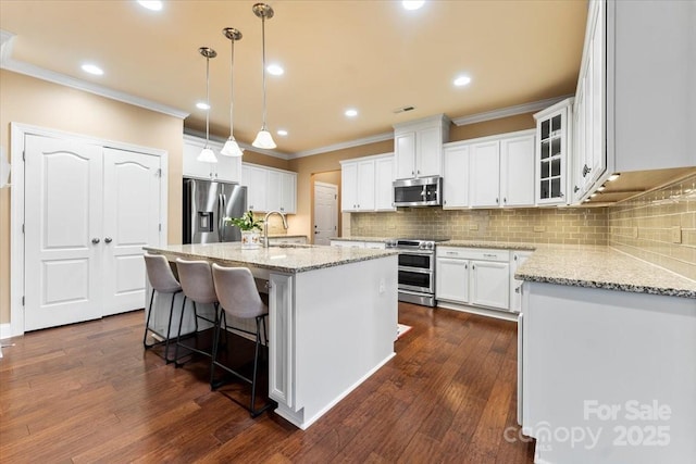 kitchen with dark wood-style floors, stainless steel appliances, light stone counters, and a sink