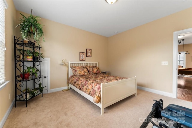 bedroom with light carpet and baseboards