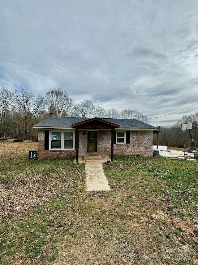 ranch-style home featuring brick siding and a front lawn