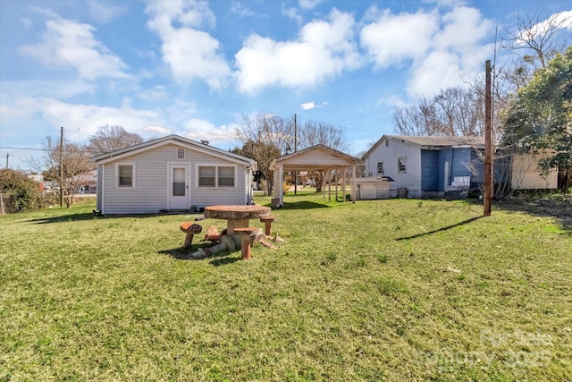 rear view of property with a carport and a lawn