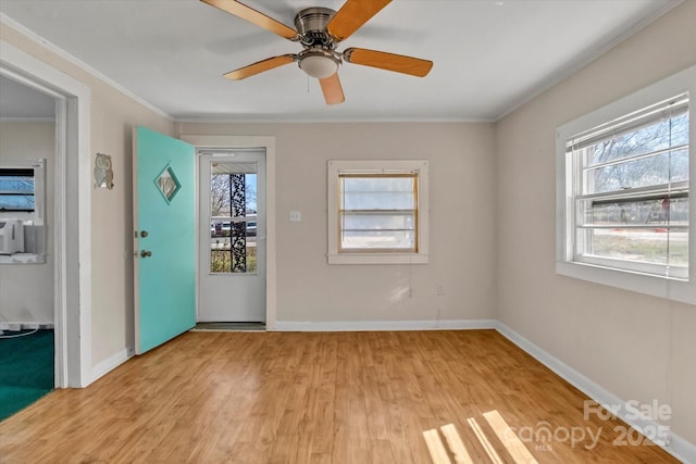 empty room with light wood-style floors, ornamental molding, baseboards, and ceiling fan