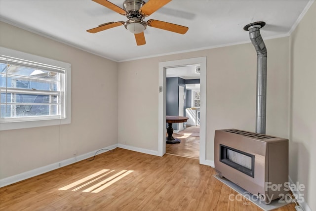 interior space featuring a wood stove, light wood-style floors, ornamental molding, and heating unit