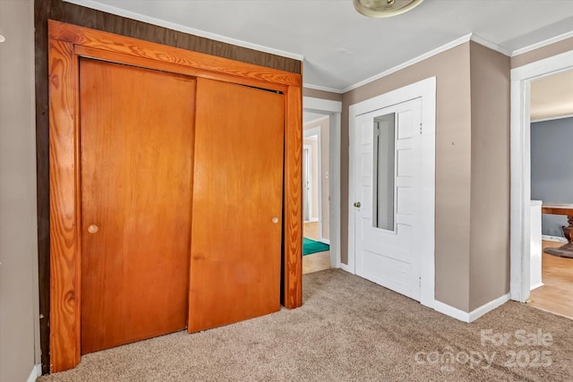 unfurnished bedroom featuring baseboards, a closet, ornamental molding, and carpet flooring