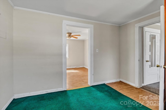 unfurnished room featuring baseboards, wood finished floors, and crown molding