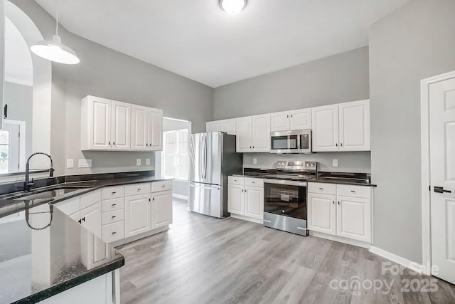 kitchen featuring appliances with stainless steel finishes, white cabinets, and a sink