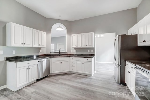 kitchen with dark countertops, white cabinetry, stove, and stainless steel dishwasher