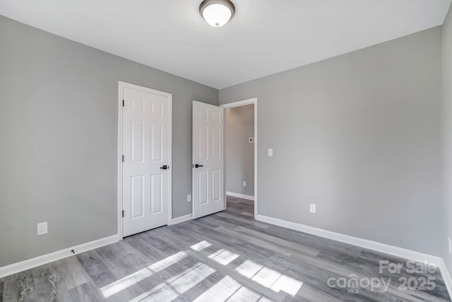 unfurnished bedroom featuring baseboards and wood finished floors