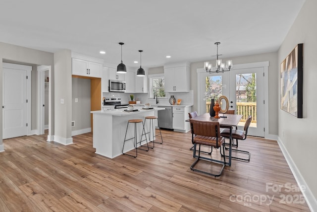 kitchen featuring a notable chandelier, white cabinets, appliances with stainless steel finishes, and light countertops