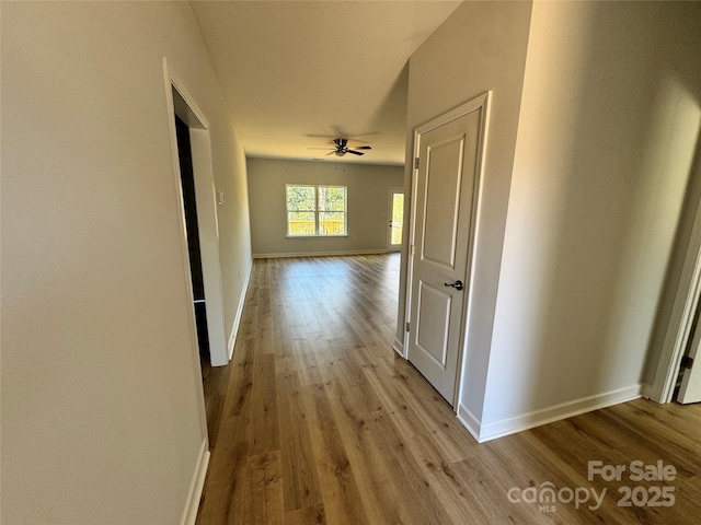 hallway featuring baseboards and wood finished floors