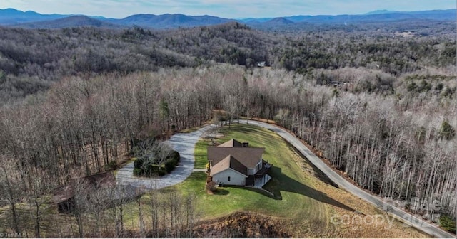 birds eye view of property with a forest view and a mountain view