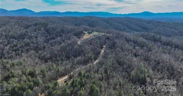 aerial view with a mountain view and a wooded view