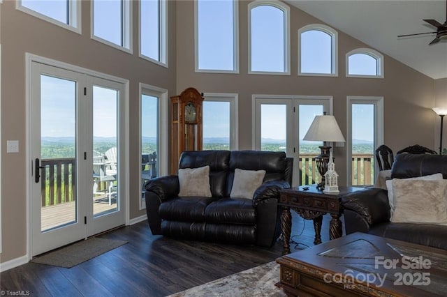 living area featuring dark wood-style flooring, a healthy amount of sunlight, ceiling fan, and baseboards