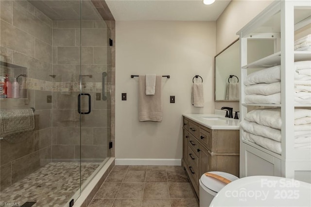 bathroom with a stall shower, baseboards, toilet, tile patterned floors, and vanity