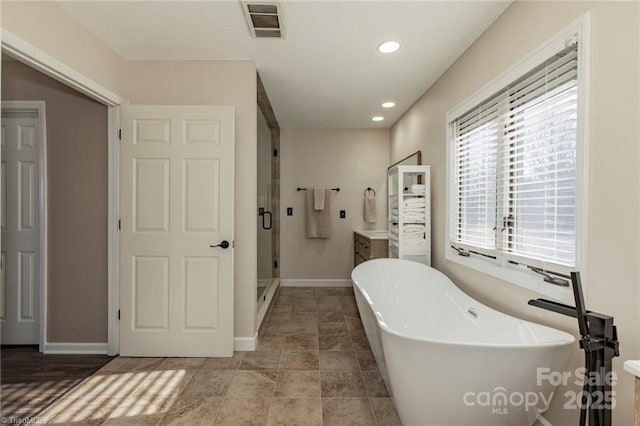 bathroom featuring a stall shower, baseboards, visible vents, a soaking tub, and recessed lighting