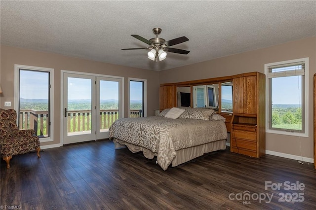 bedroom featuring access to exterior, baseboards, dark wood finished floors, and a textured ceiling