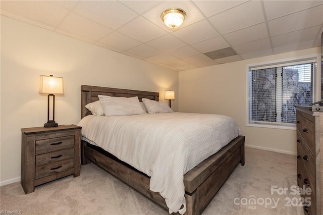 bedroom with baseboards, light carpet, and a drop ceiling