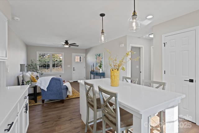 kitchen featuring decorative light fixtures, light countertops, dark wood-type flooring, a ceiling fan, and white cabinets