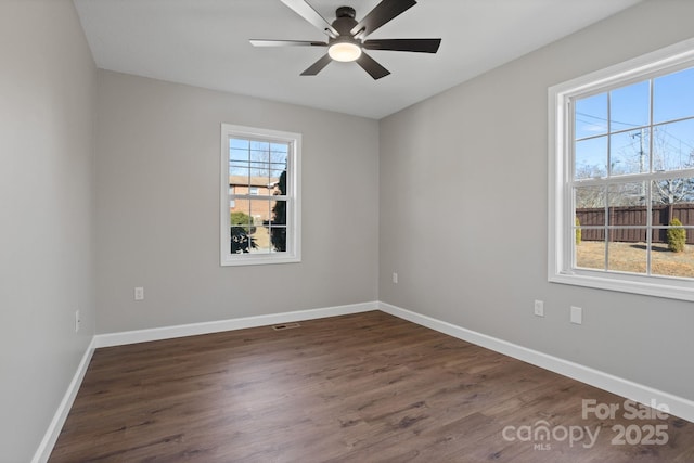 unfurnished room with visible vents, ceiling fan, baseboards, and wood finished floors