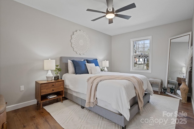 bedroom with ceiling fan, wood finished floors, and baseboards