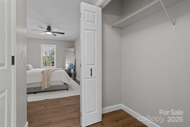 unfurnished bedroom featuring a ceiling fan, dark wood finished floors, and baseboards