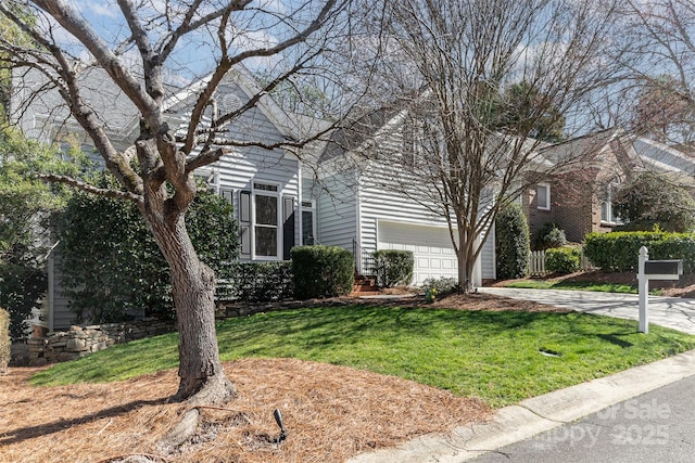 view of property hidden behind natural elements with driveway and a front lawn