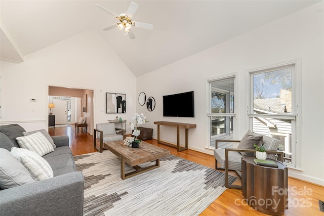 living room featuring light wood-style floors, ceiling fan, and high vaulted ceiling