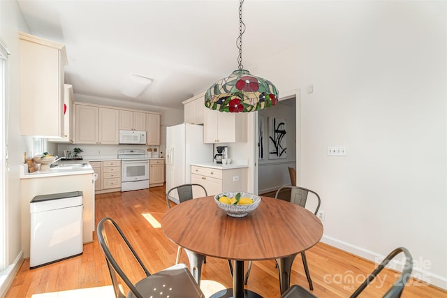 dining space featuring light wood-style floors and baseboards