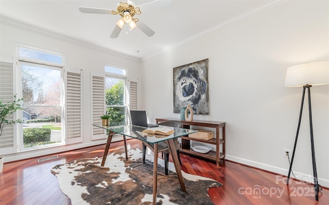 home office featuring ceiling fan, visible vents, baseboards, ornamental molding, and wood-type flooring